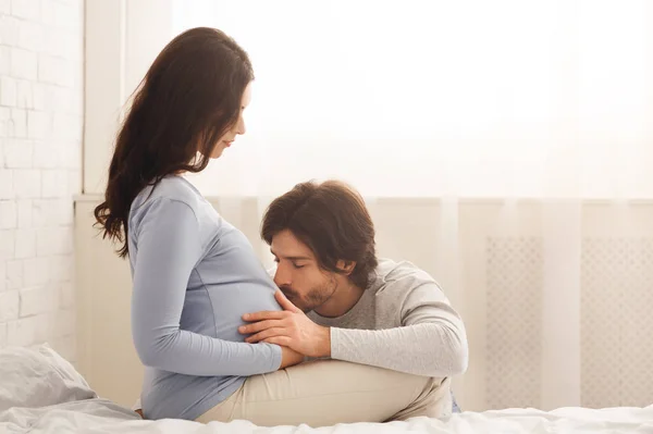 Future dad tenderly kissing belly of his pregnant wife — 스톡 사진