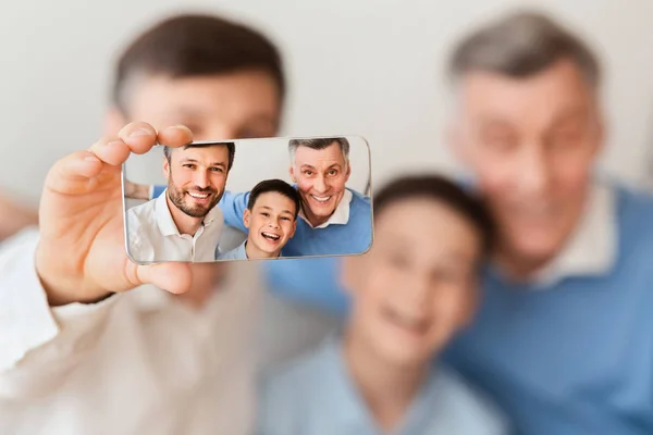 Uomo, suo figlio e anziano padre making selfie seduta in casa — Foto Stock
