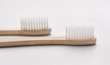 Beyaz arka planda iki bambu doğal diş fırçası.
