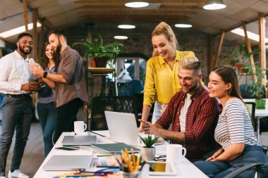 Yaratıcı ekip dizüstü bilgisayarda yeni pazarlama stratejisini tartışıyor