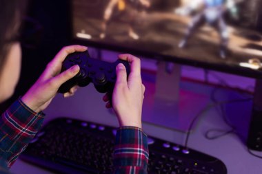 Female gamer holding joystick and playing video game clipart