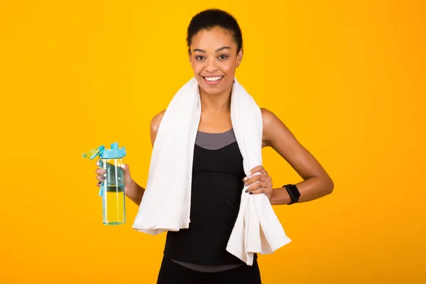 Deportiva mujer negra sosteniendo botella de agua de pie, Studio Shot — Foto de Stock