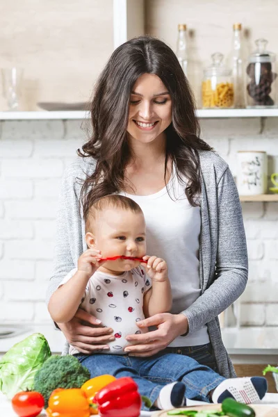 Junge Mutter bereitet mit Baby-Sohn gesundes Gemüse zu — Stockfoto