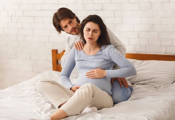 걱정하는 남편은 임신부에게 복통으로 고생하는 것을 위로 하였다 — 스톡 사진
