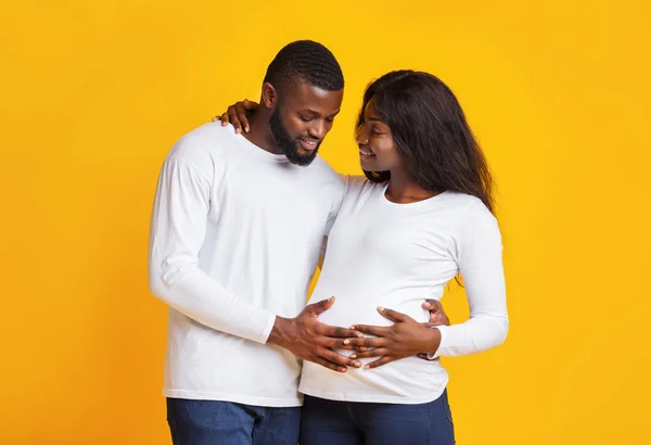 Homem apaixonado tocando sua barriga esposa grávida — Fotografia de Stock