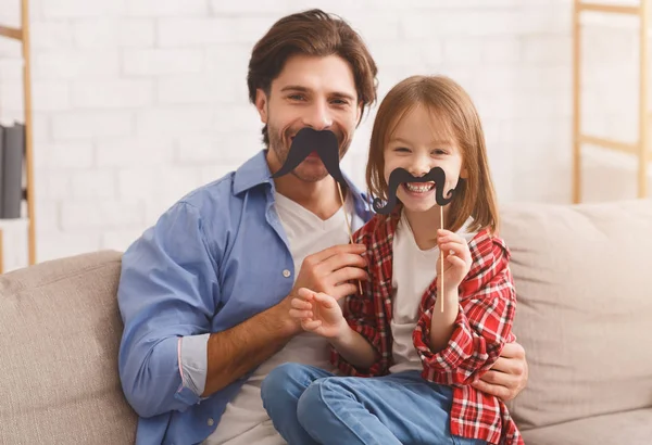 Piękna zabawna dziewczyna i tatuś mają wąsy na patykach — Zdjęcie stockowe