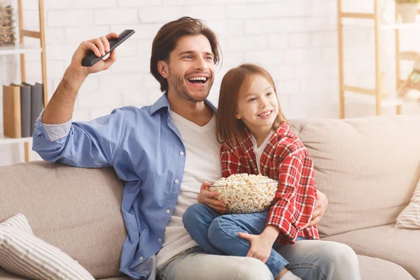 Far og datter ser fodboldkamp på tv sammen - Stock-foto