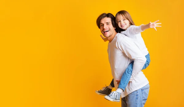 Alegre papá está sosteniendo a su hija feliz en su espalda —  Fotos de Stock