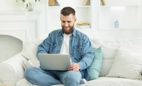 Millennial hombre que trabaja en el ordenador portátil en la oficina en casa — Foto de Stock