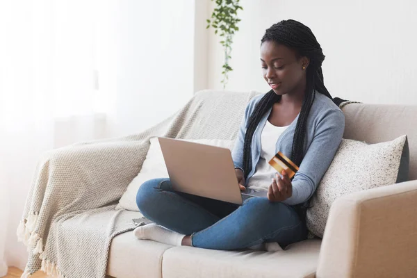 Afro ragazza utilizzando il computer portatile e carta di credito per lo shopping online — Foto Stock