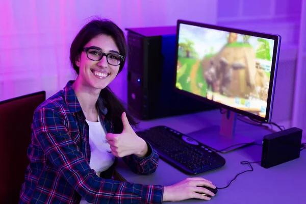 Joyful gamer menina jogando jogos de vídeo e mostrando polegar para cima — Fotografia de Stock