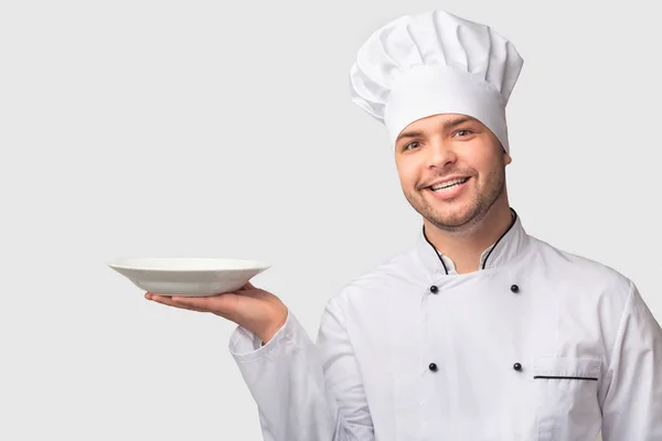 Chef Man Holding Lempeng Kosong Senyum Berdiri di Atas Latar Belakang Putih — Stok Foto
