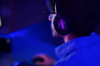 Kulaklık takan ve online nişancı oyunu oynayan oyuncu