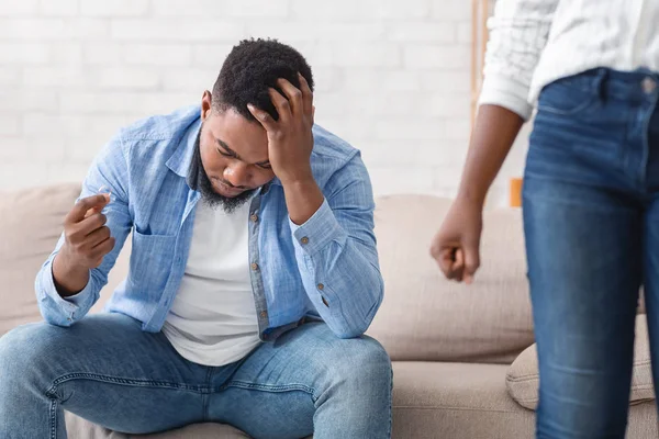 Depressed black man holding wedding ring while his wife leaving him — Stock Photo, Image