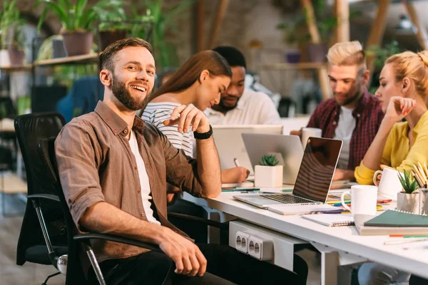 Love my job. Programmer smiling to camera, sitting in coworking office — Stock Photo, Image