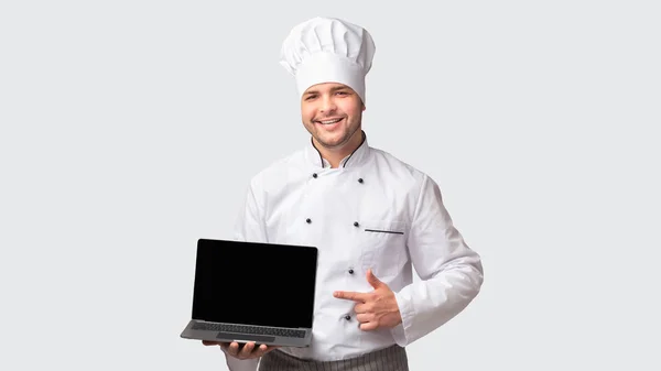 Chef Man segurando laptop com tela em branco em pé, fundo branco — Fotografia de Stock