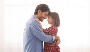 Sevgili baba ve kızı evde birbirlerine sarılıyorlar.