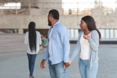 Başka bir kadına dik dik bakan sadakatsiz erkek arkadaşına kızgın bir kız arkadaş.