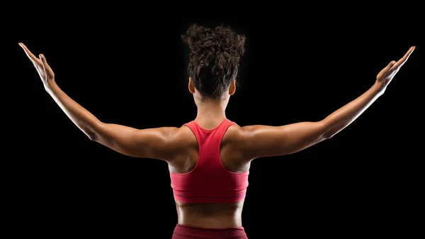 Siyahi kadın vücut geliştiricisinin ellerini kaldırışının arkası. — Stok fotoğraf