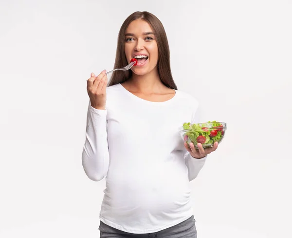 幸せな妊婦食べる野菜サラダ、スタジオショット — ストック写真