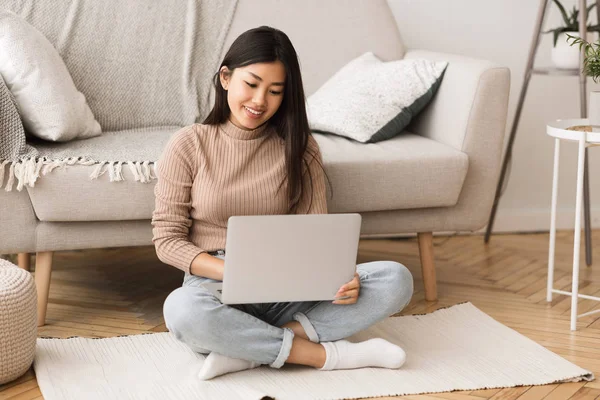 Ung frilansare arbetar på laptop, sitter på golvet — Stockfoto