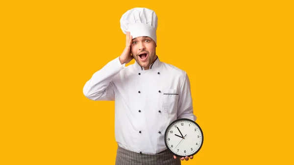 Chef sorprendido hombre celebración reloj de pie sobre fondo amarillo, Panorama — Foto de Stock