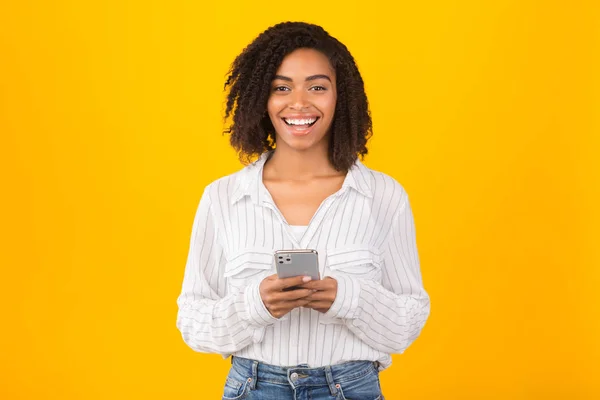 Χαμογελαστό μαύρο κορίτσι χρησιμοποιώντας iphone 11 pro max — Φωτογραφία Αρχείου