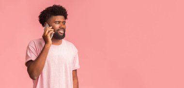 Rahatlamış adam telefonla konuşuyor ve boş alana bakıyor.