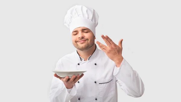 Chef hombre sosteniendo placa oliendo plato sobre fondo blanco, Panorama —  Fotos de Stock