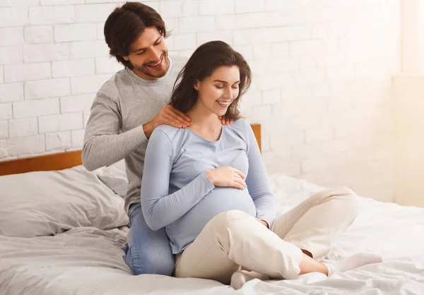 Amante marido haciendo masaje de espalda a su feliz esposa embarazada — Foto de Stock