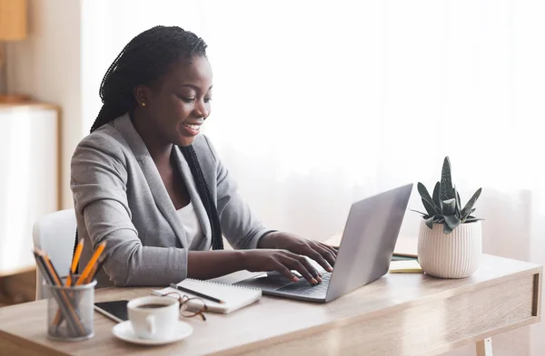 Empleada afroamericana usando laptop en el lugar de trabajo en la oficina —  Fotos de Stock