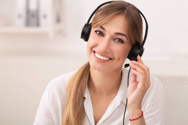 Portrait Of Hotline Operator In Headset Smiling Sitting In Office
