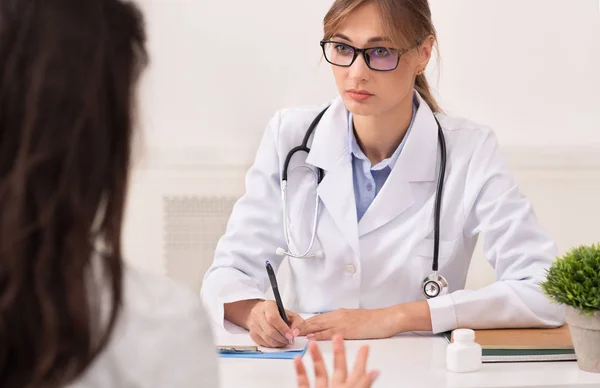 Sério Médico Mulher Vendo Paciente Feminino Sentado No Local de Trabalho — Fotografia de Stock