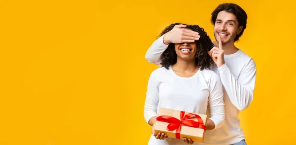 Šťastný milující chlap dělat překvapení dárek pro jeho černošky přítelkyně — Stock fotografie
