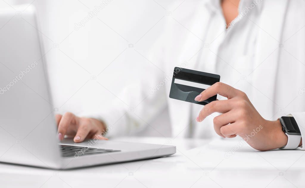 Closeup of girl making purchases using laptop computer