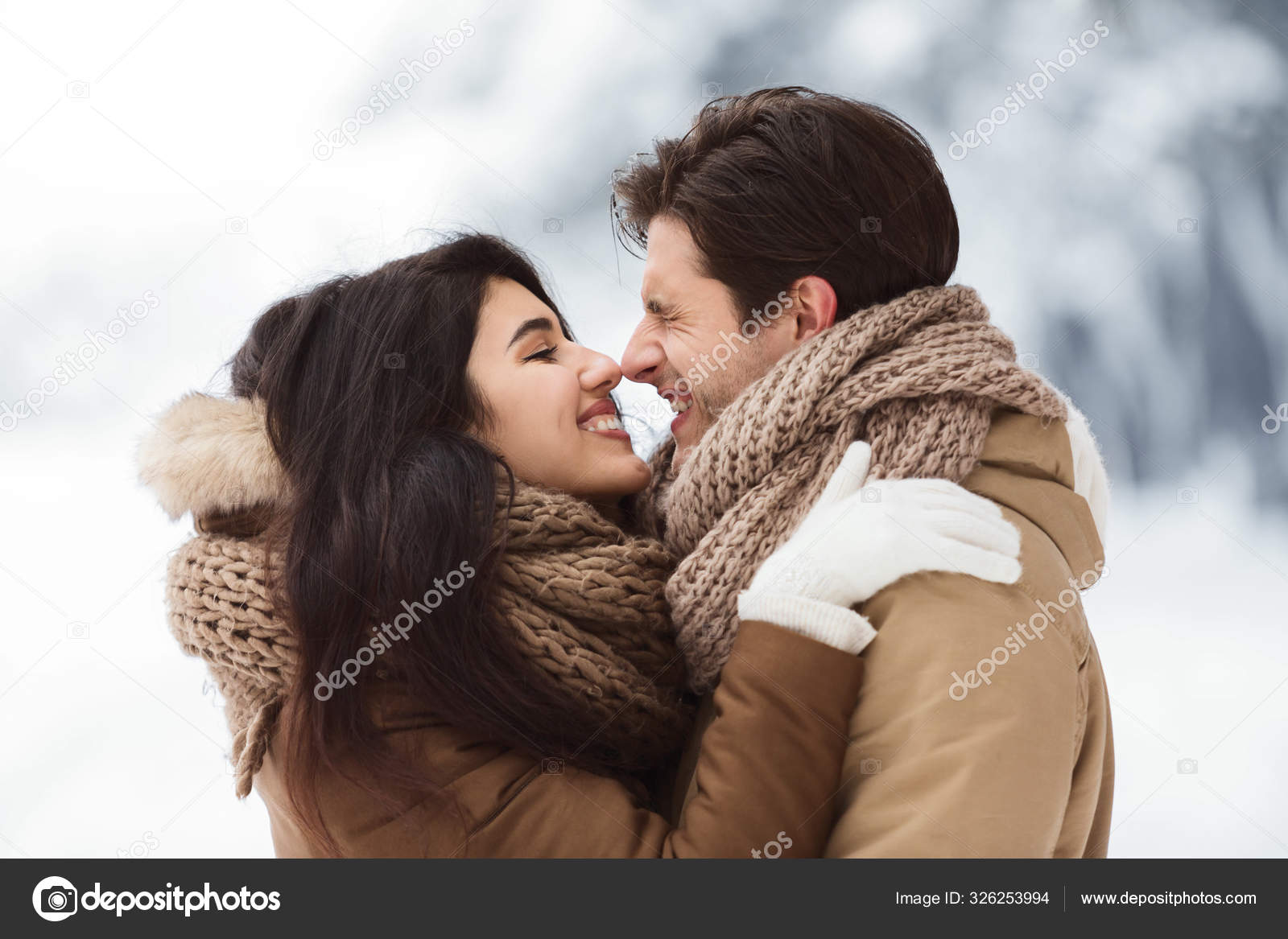 Cute Lovers Rubbing Their Noses Embracing Standing In Snowy Park