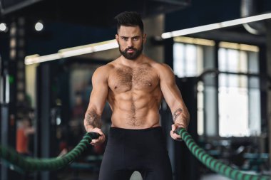 Genç formda sporcu spor salonunda çalışıyor.