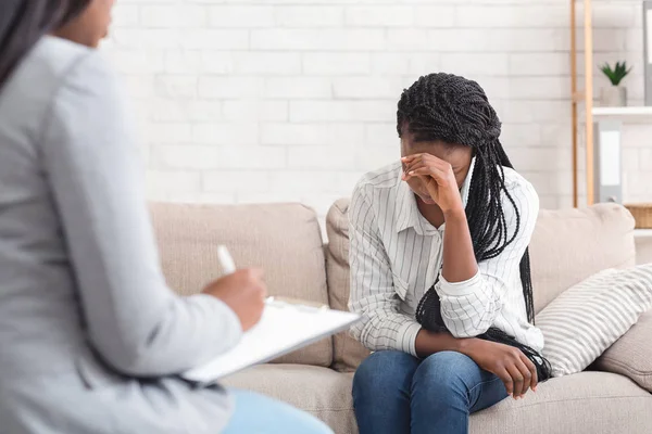 Depressieve vrouw zit op de bank bij psychotherapie sessie in coucellors kantoor — Stockfoto