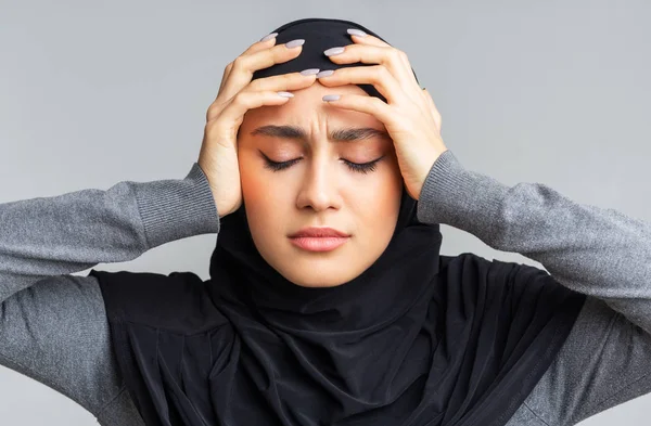 Zaklatott muszlim nő Hidzsábban fejfájástól szenved, megérinti a halántékát — Stock Fotó