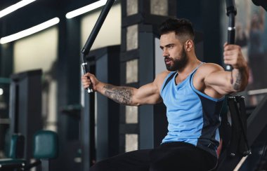 Sportif adam spor salonunda antrenman yapıyor.