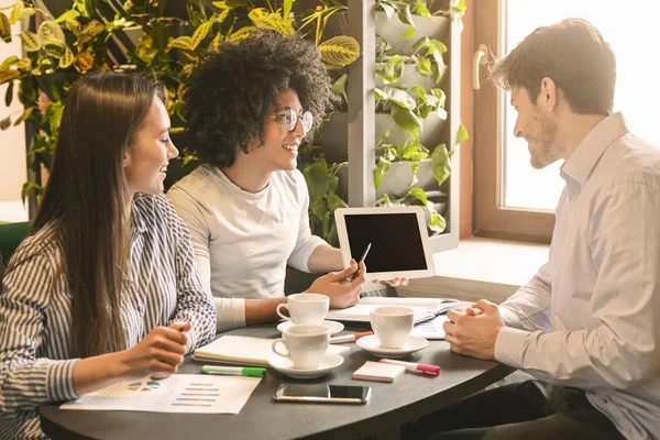 Millennials partners diskuterar projekt under affärslunch — Stockfoto