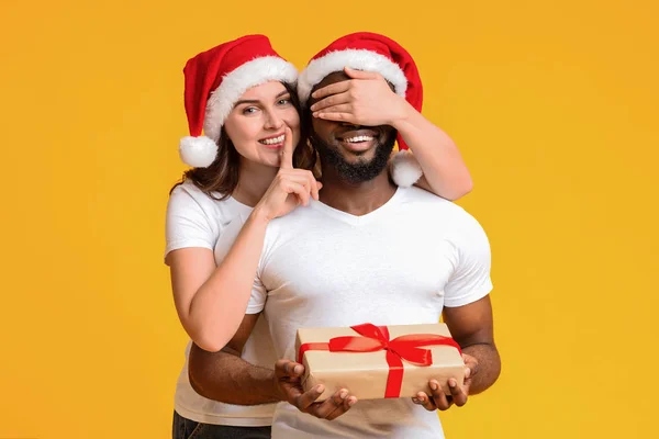 Affettuosa donna a Babbo Natale cappello preparato regalo di Natale al suo fidanzato — Foto Stock