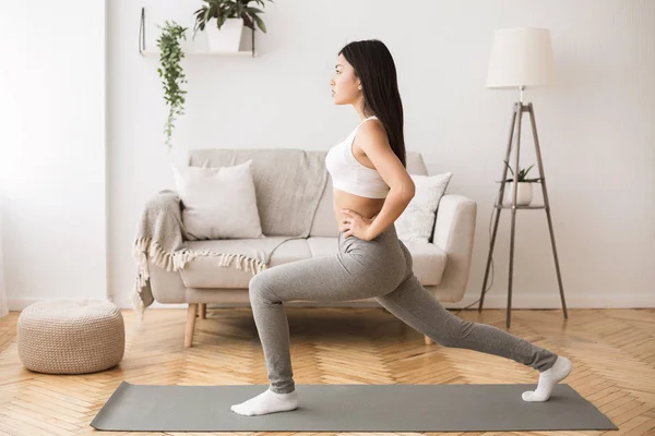 Meisje doet aerobics opwarmen voor flexibiliteit, benen strekken — Stockfoto