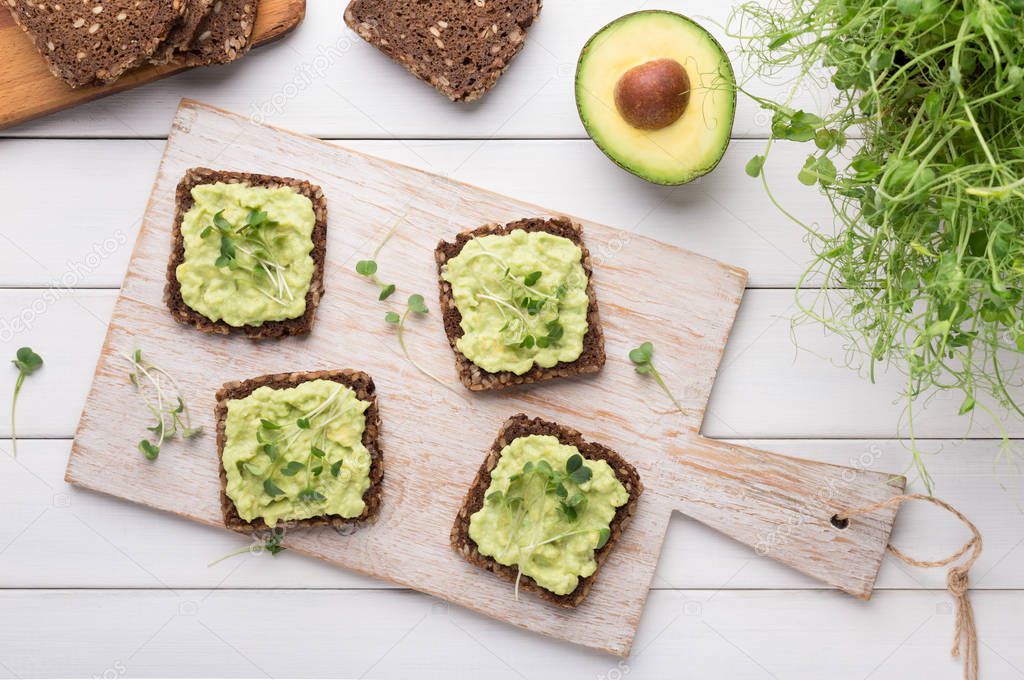 Rye bread sandwiches with avocado spread and microgreen