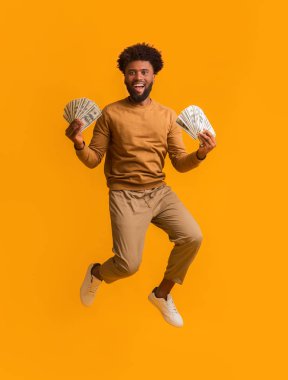 Zaferi kutlayan süper mutlu afro adam, elinde bir sürü para var.