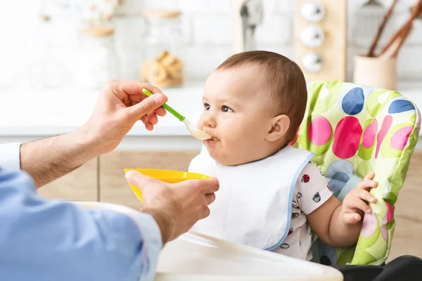 Тоддлер ест здоровую детскую еду на кухне — стоковое фото