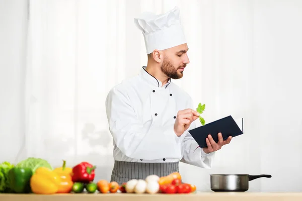 Chef Uomo lettura Ricetta culinaria Libro Preparazione Cena in cucina — Foto Stock