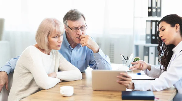 Mexican doctor explaining diagnosis to elderly couple — Stock Photo, Image