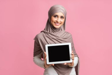 Siyah ekranlı dijital tablet gösteren tesettürlü Müslüman kız