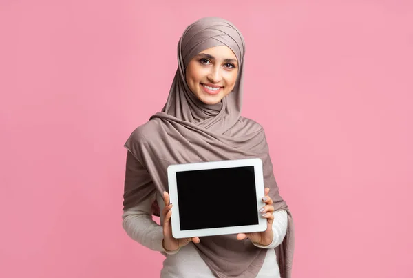 Muslim gadis dalam jilbab menunjukkan tablet digital dengan layar hitam — Stok Foto